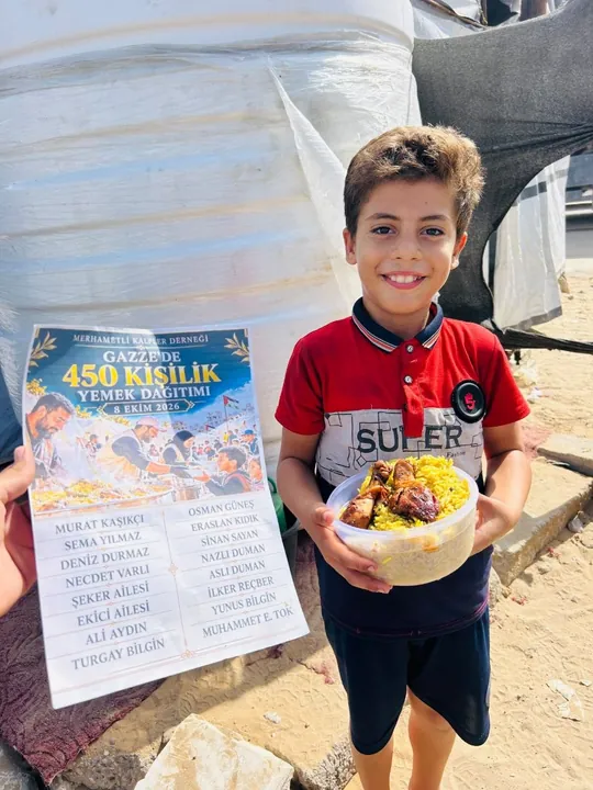 Yemek kabını tutan gülümseyen bir çocuk ve yemek dağıtımı afişi